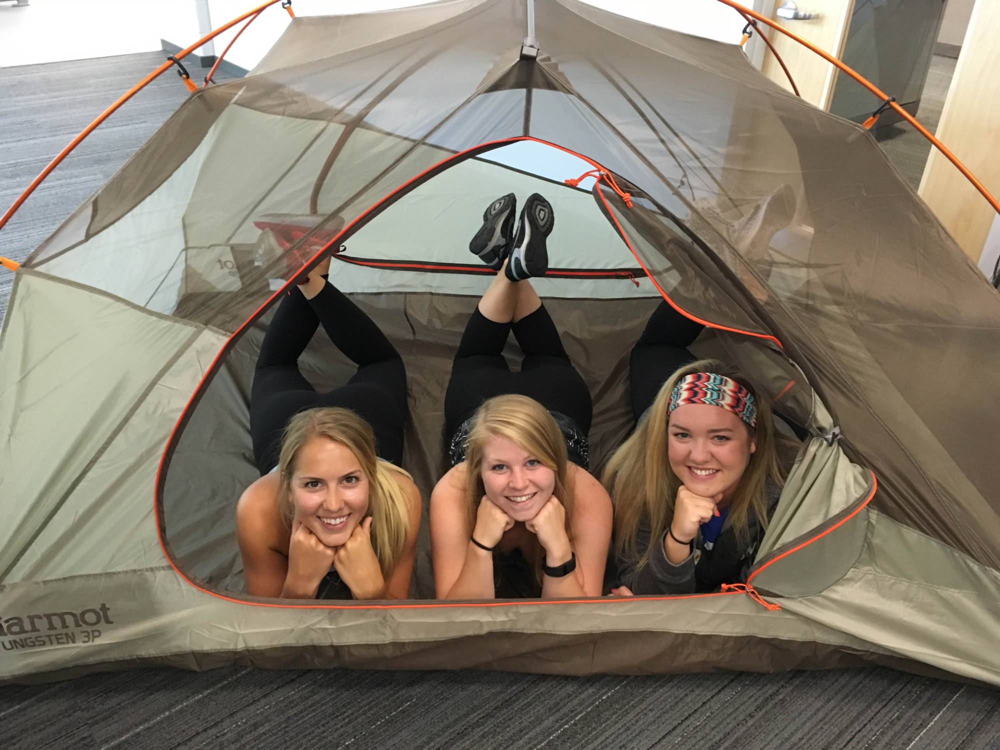 Students smiling in a tent